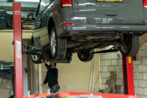 A person works on the underside of the van before works begin